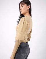 model looks over one shoulder the nina balloon sleeve knit top in beige