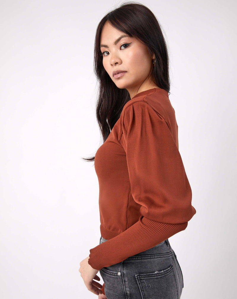 model looks over her shoulder while wearing the Nina Brown Balloon Sleeve Knit Top with grey jeans with her hands in her pocket