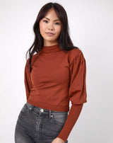 model wears the Nina Brown Balloon Sleeve Knit Top with grey jeans