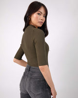 model looks over shoulder in the olive meg ribbed mid sleeve bodysuit in black with grey jeans