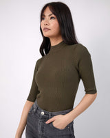 model has hand in pocket with the olive meg ribbed mid sleeve bodysuit in black with grey jeans