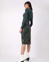 full length image of the model in the lorna green turtleneck ribbed knit bodysuit with pu green skirt with white boots
