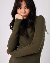 close up cropped image of the model leaning on her arm in the liana olive green roll neck knit midi dress