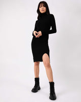 the model poses with hands in front of her in the liana black roll neck knit midi dress and military style boots