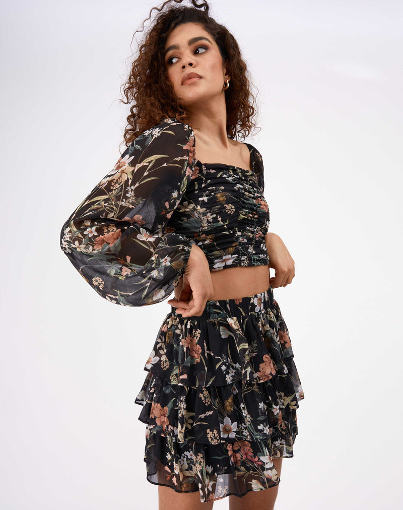 model has hands by her hips wearing the Marina Black Floral Gathered Top with her matching skirt