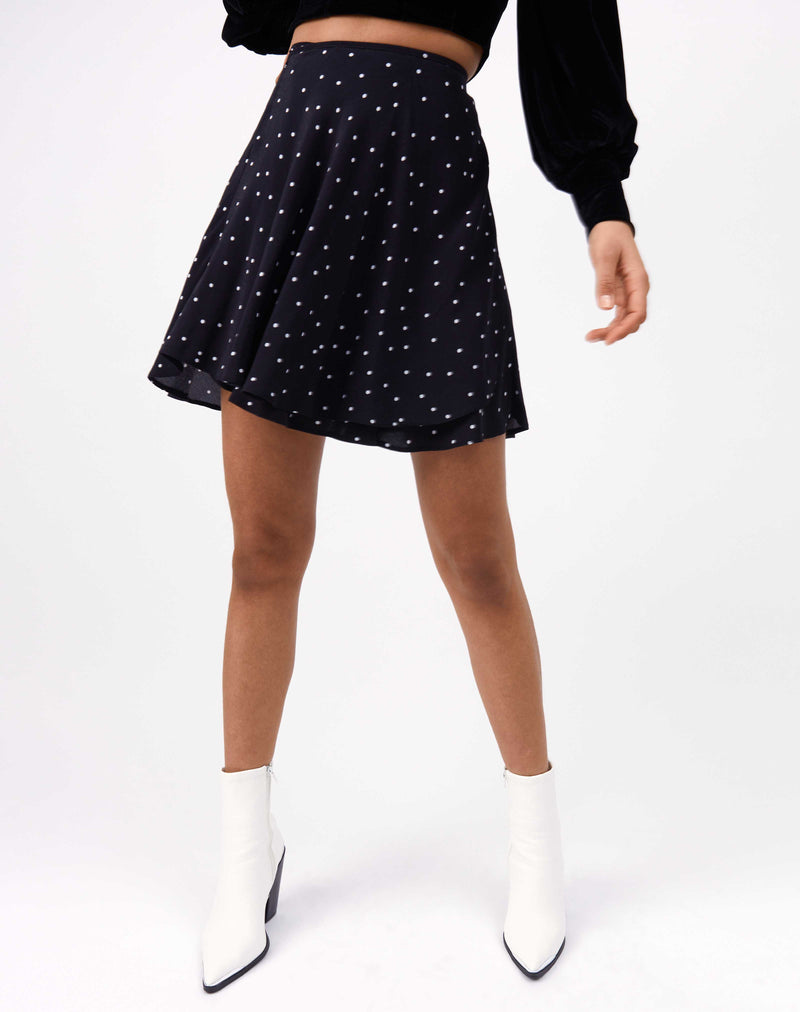 close cropped image of model wearing the lois polka dot wrap mini skirt with white boots
