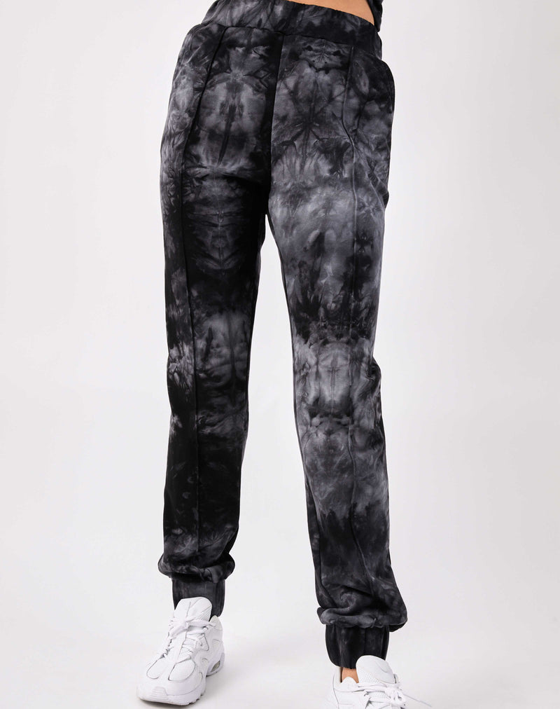 a close cropped image of a model wearing the Saskia Grey Tie Dye Joggers with white trainers