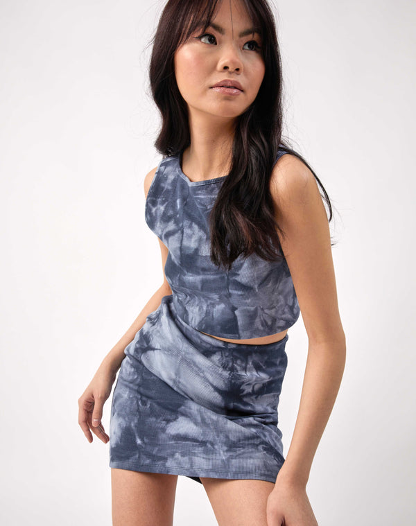 the model bends towards the camera wearing the angie ribbed blue tie dye top and matching top in a studio