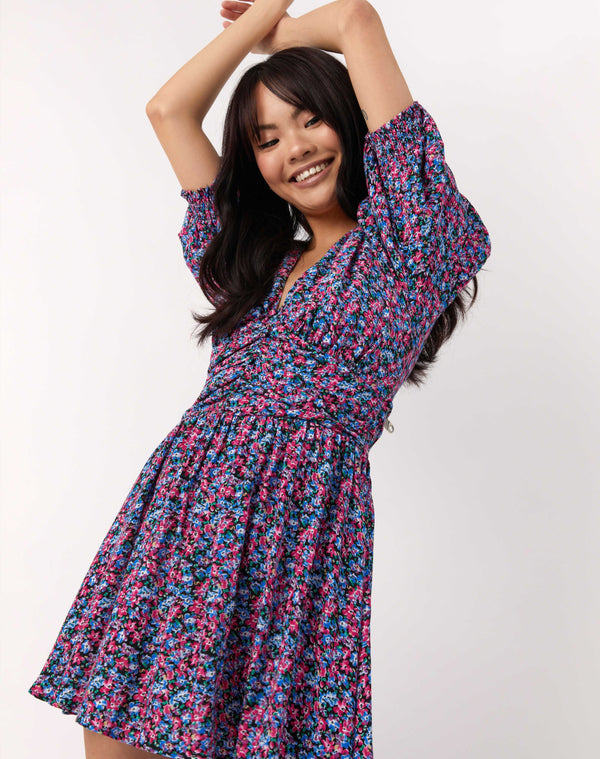model poses with arms up wearing the Sasha Multi Floral Dress