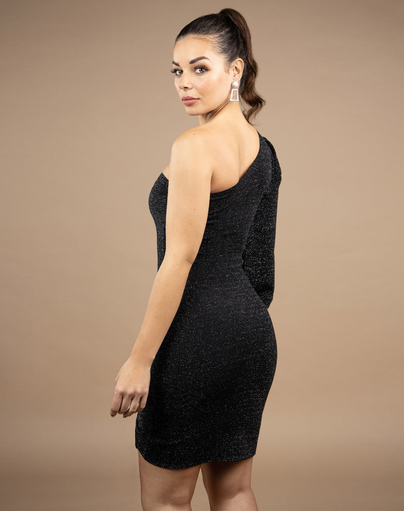 model looks over her shoulder in the jessie one shoulder lurex dress showing the back of the dress