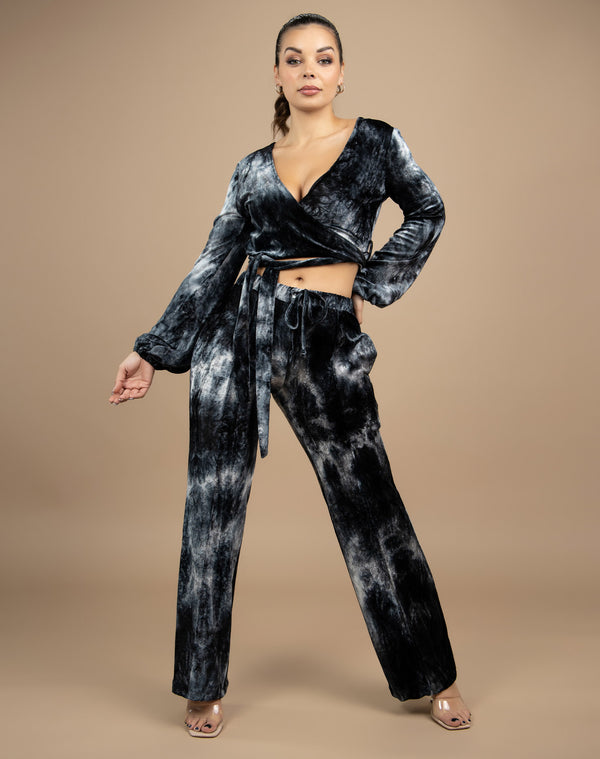 a full length image of the model wearing the fran tie dye velour wrap top with side tie and matching trousers