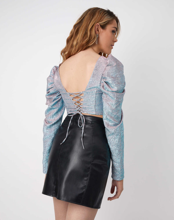 a back image of a model wearing the eve iridescent corset top showing the lace up back and paired with a black pu skirt