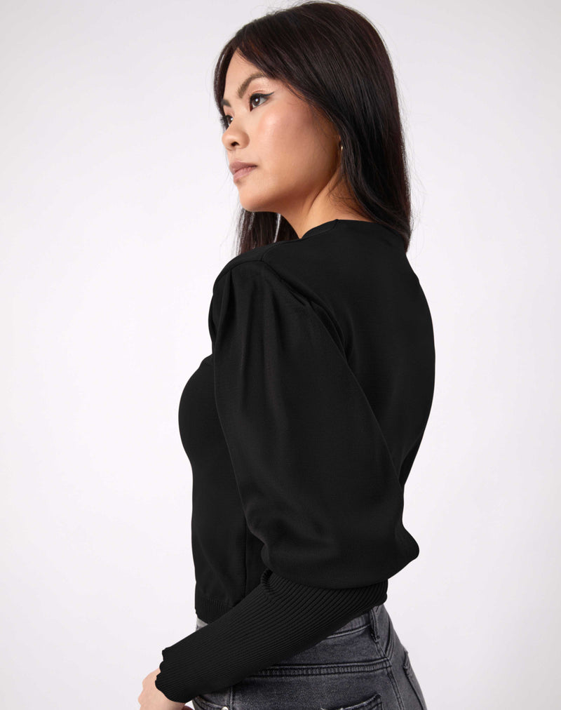 model looks over her shoulder the nina balloon sleeve knit top in black with grey jeans