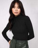 model wears the lorna black turtleneck ribbed knit bodysuit with green pu skirt