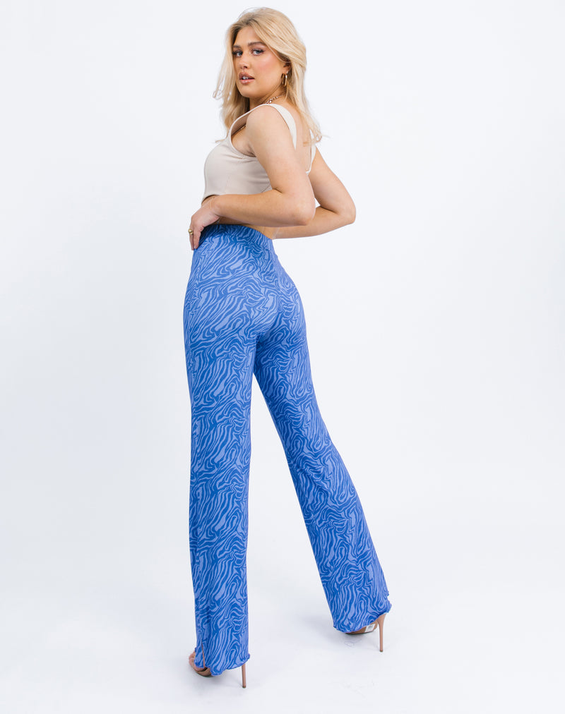 the model faces away from the camera showing the back of the Ariana High Wasited Trousers in Blue Zebra with a nude corset