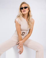 cropped in image of the model sat down wearing the Laura One Shoulder Jumpsuit in Ribbed Oyster in sunglasses