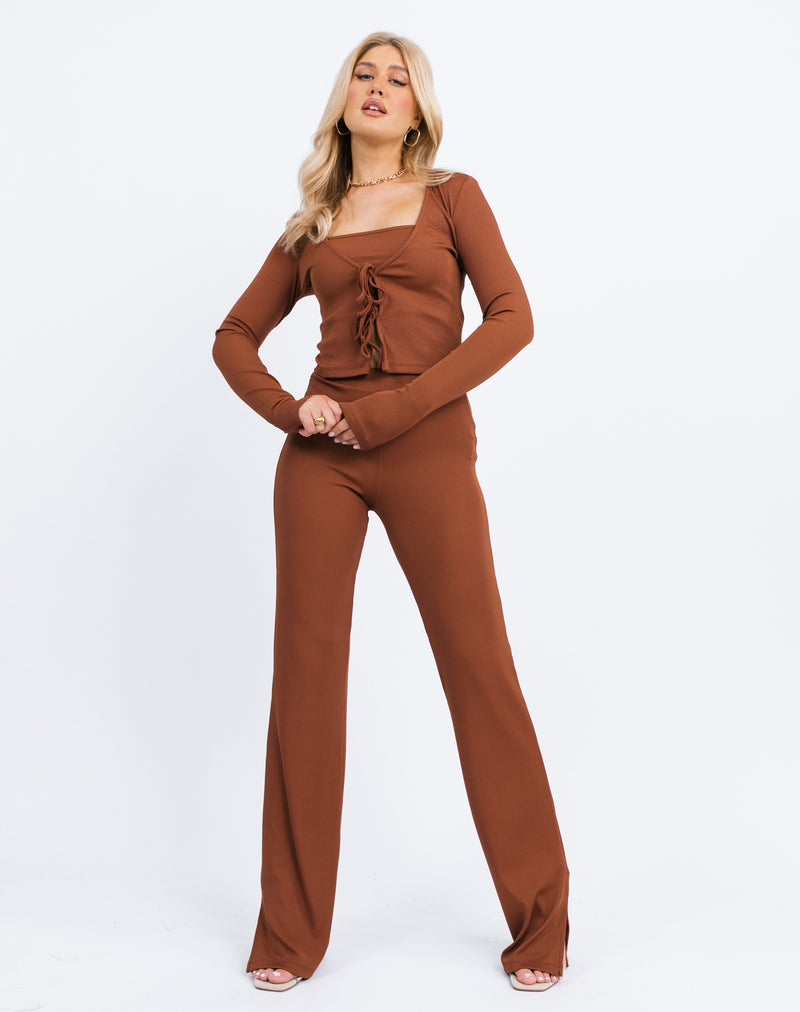 the model wears the Frankie Ribbed Tie Front Top & Bandeau in Chocolate in a full length shot with matching trousers, holding her hands together