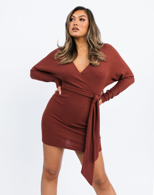 the model has two hands on her hips showing the Lotta Wrap Mini Dress In Chocolate Fluffy Rib