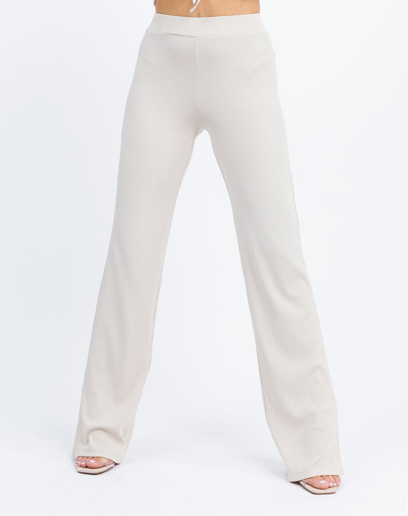 a cropped in image of the model wearing the Lana Wide Leg Trousers in Beige Rib with heels