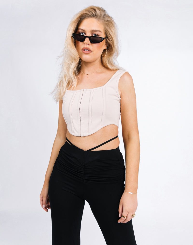 the model poses with sunglasses wearing the Lauren Corset Top in Oyster Rib with black ruched trousers