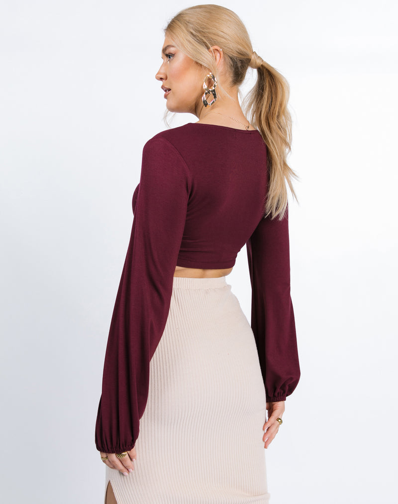 model faces away from the camera showing the back of the Skye Ruched Front Crop Top in Grape