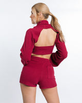 the model faces away from the camera showing to back of the Becky Roft Ribbed Shorts in Raspberry