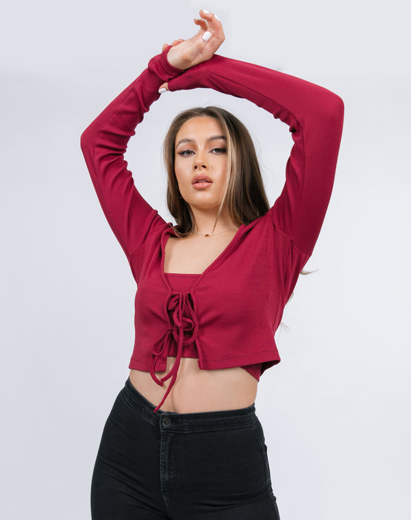 the model hold her arms up wearing the Frankie Ribbed Tie Front Top & Bandeau in Raspberry with black jeans