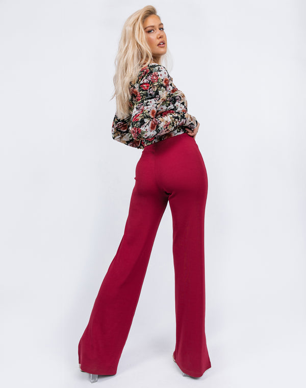 we see the back of the Lana Wide Leg Trousers in Raspberry Rib on the model while she looks over her shoulder in a floral top