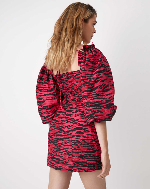 we see the model from behind wearing the charlotte pink animal puff sleeve dress with square neckline and mini length